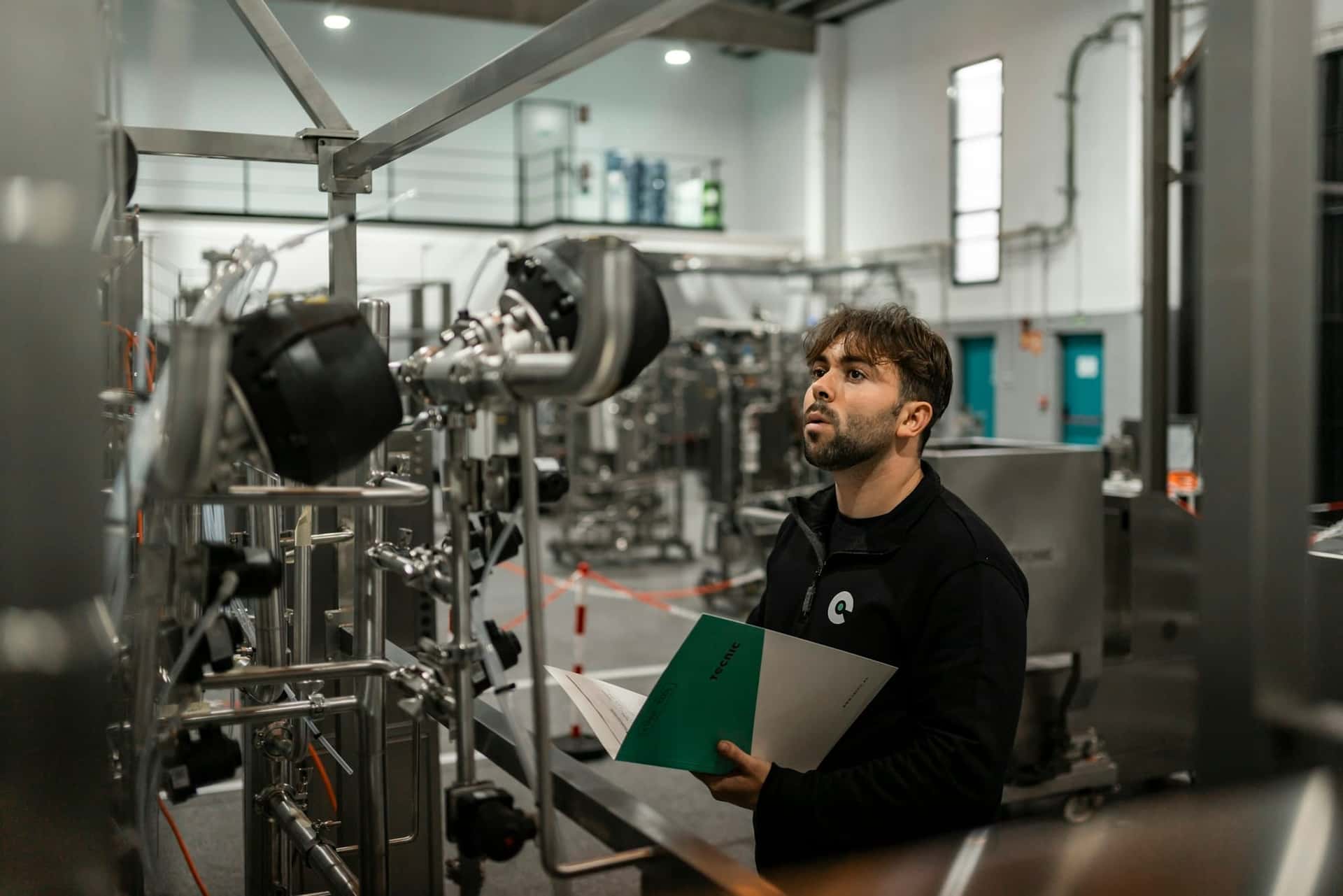 Engineer reviewing production equipment in a factory